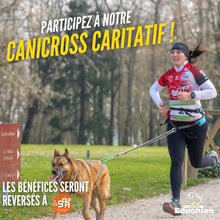 Charger l&#39;image dans la galerie, Photo d’une participante courant en canicross avec son chien, attaché à une longe, dans un parc forestier. Le visuel annonce un événement caritatif dont les bénéfices seront reversés à la SPA, organisé par Educhien. EDUCHIEN FORMATION
